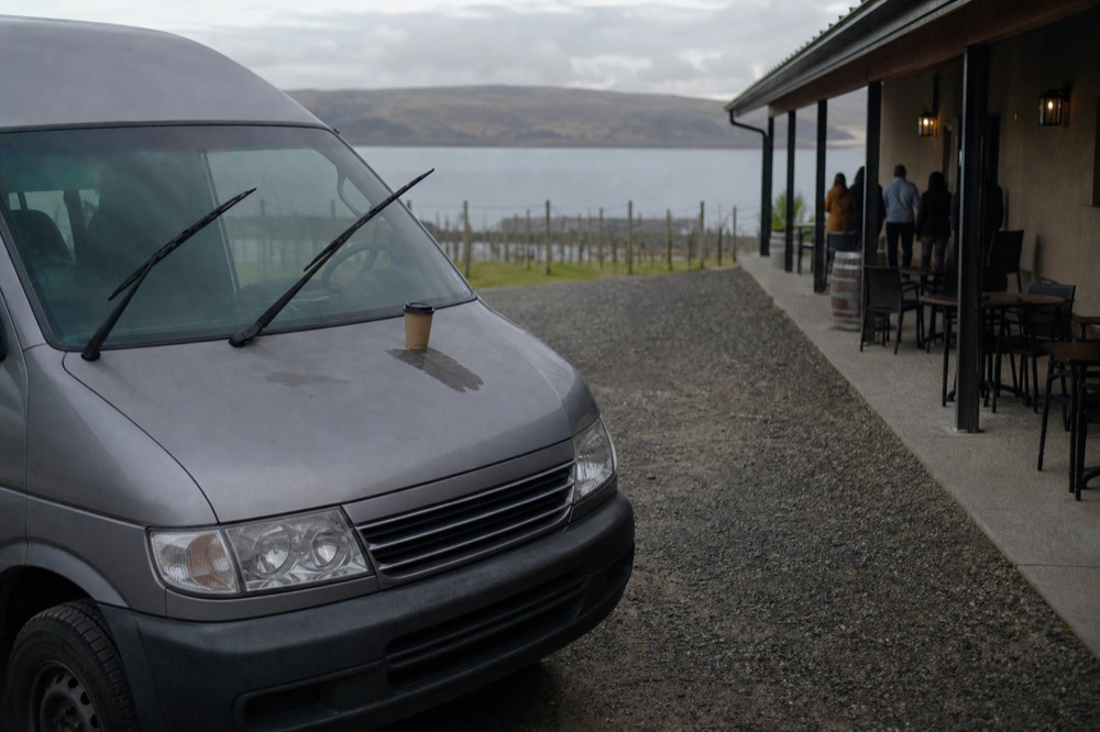 A passenger van parked outside a lakeside winery tasting room, no text, no logos, no people