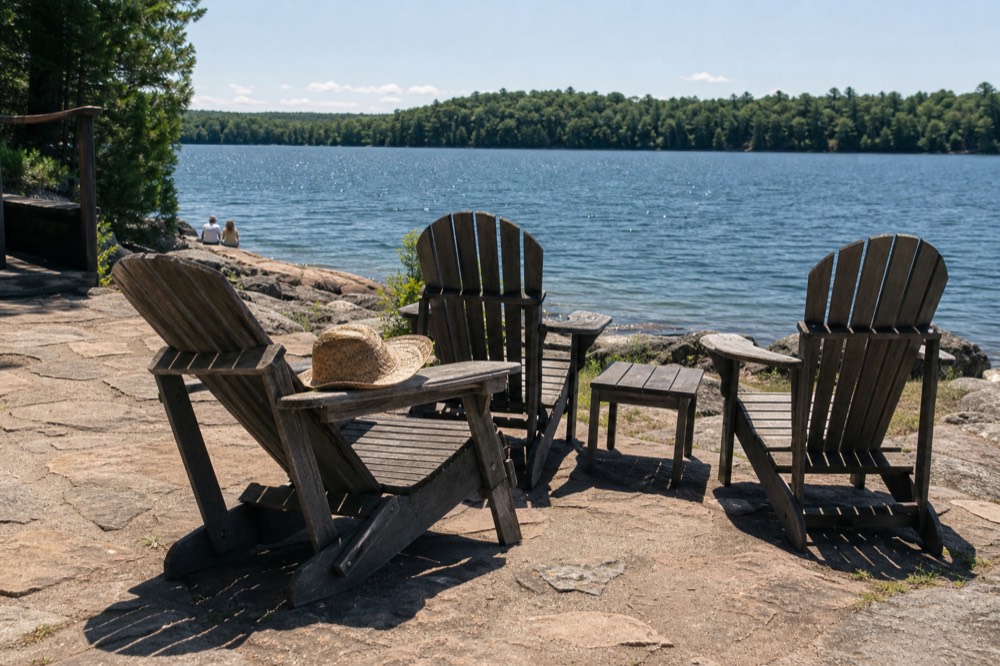 A sunny patio with Adirondack chairs overlooking a lake, no text, no logos, no people