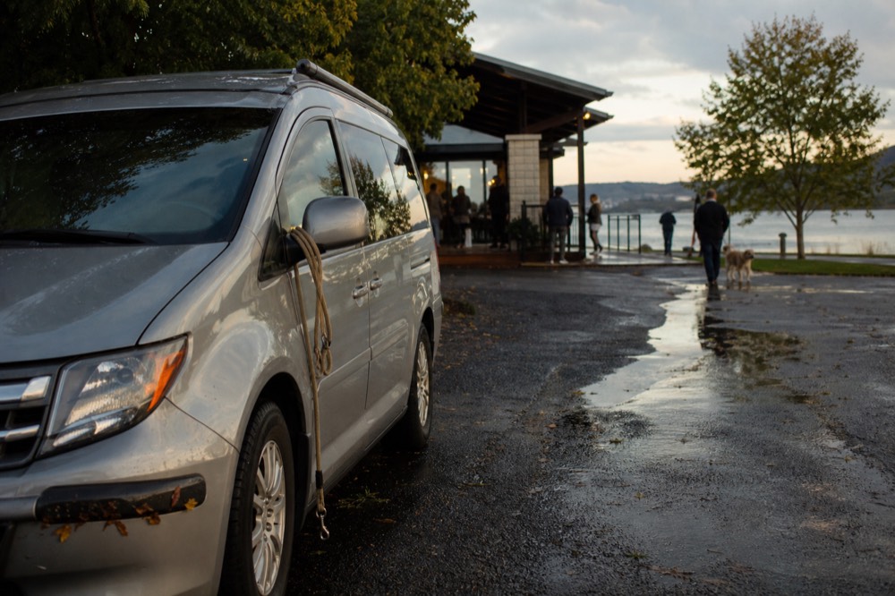 Small van parked outside a lakeside winery tasting room, no text, no logos, no people