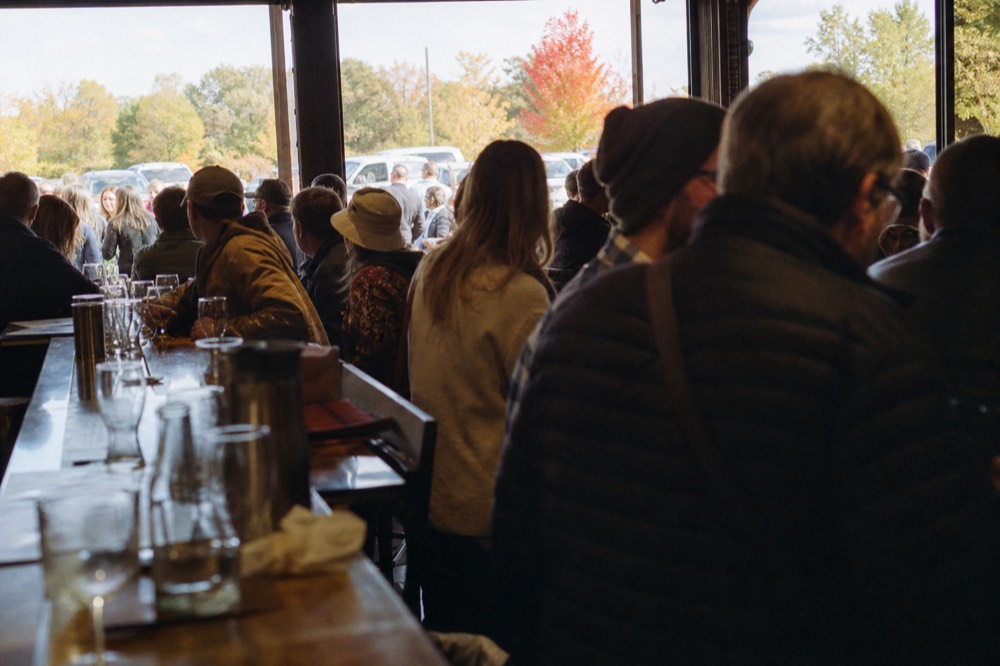 Guests seated at a crowded winery tasting bar on a busy weekend afternoon, no text, no logos, no people
