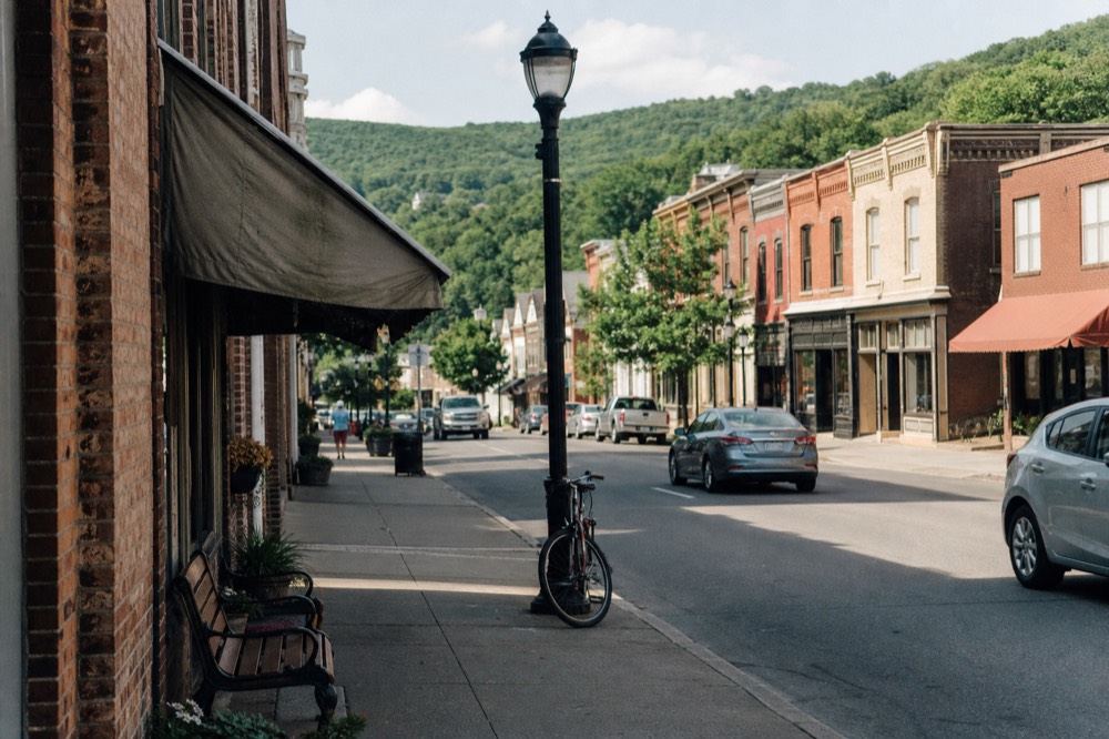 Village street in Watkins Glen with storefronts and hills above Seneca Lake, no text, no logos, no people